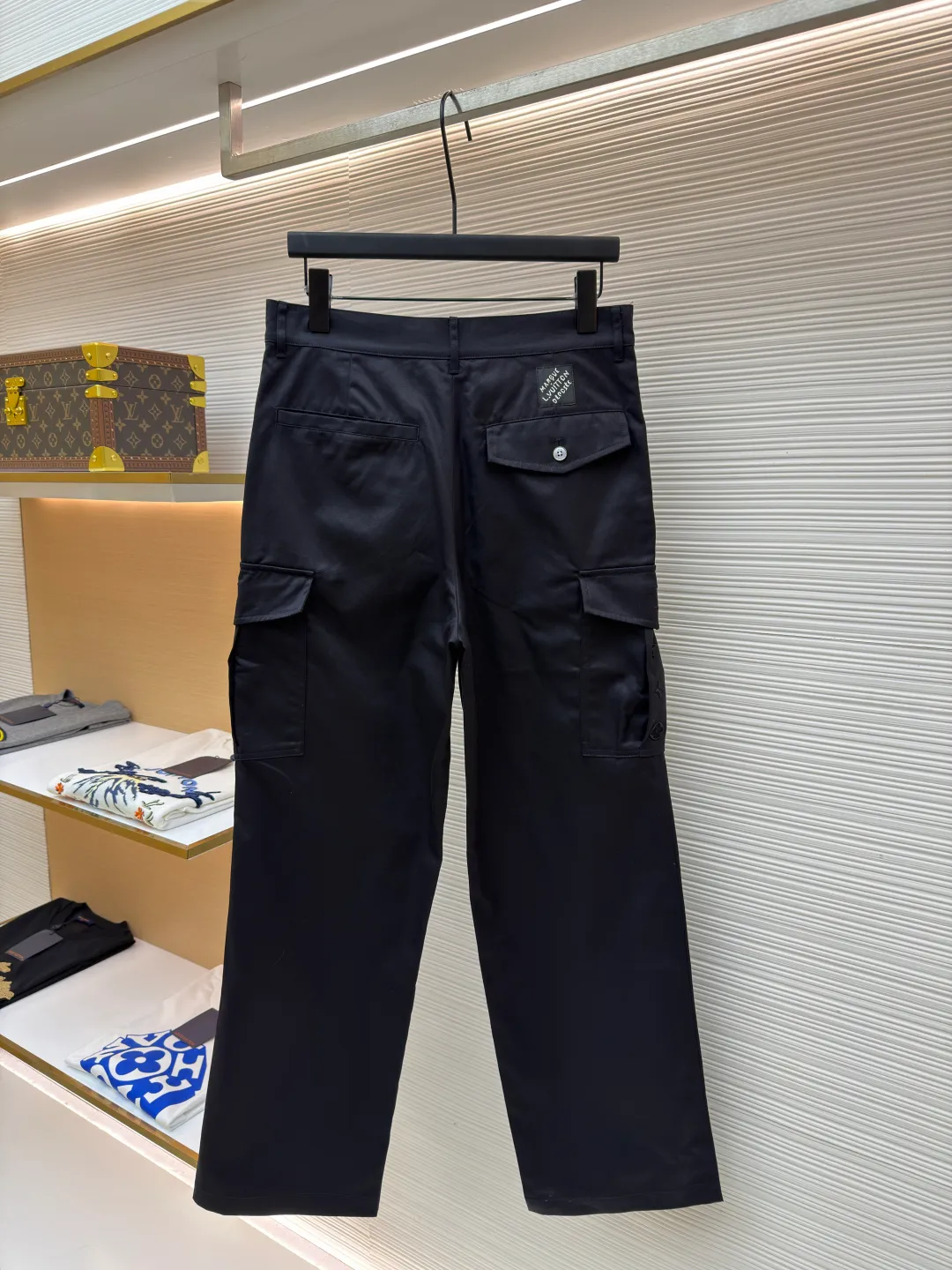 LOUIS VUITTON pocket embroidered work trousers ●Original version: Purchased and developed by 12324 ●Item number: 1682341-B50 ●Fabric: cotton twill fabric ●Technology: embroidery production ●Color: black ●Version: fitted version ●Weight: about 535 grams ●Size: 44-46-48-50 ●Description: The high cotton content ensures the fabric's excellent breathability, durability and classic workwear texture, while the twill weave gives it unique wear resistance and stiffness. The special fabric technology solves the pain points of tight and stiff traditional overalls; it provides greater freedom when moving, significantly improves wearing comfort and flexibility, and achieves a balance between function and comfort. The application of three-dimensional core-spinning embroidery technology in the pocket position is achieved by adding additional cotton thread or foam as the core material to the pattern filling layer, and then using embroidery thread to fully cover the embroidery. The logo pattern is significantly protruded from the surface of the fabric, forming a full three-dimensional effect. This process not only enhances the visual impact and tactile level, but also improves the wear resistance of the pocket area through the buffering effect of the core material, ensuring that the pattern can still remain crisp and not deformed in complex daily use, ensuring that the pattern is clear and durable, and injecting a sense of sophistication into the rugged workwear style. Diversified pocket system combines workwear functionality with sophistication. The flap cargo pockets on both sides are a signature element, and their flap design prevents items from falling and enhances the visual three-dimensionality. Italian style pockets provide simple side storage. The overall wiring is straight and delicate, the fabric is comfortable and soft, and the color is consistent without color difference. It can be matched with the same style to create a fashionable look and control various occasions. Customized accessories, complete with three standards, same style for men and women!